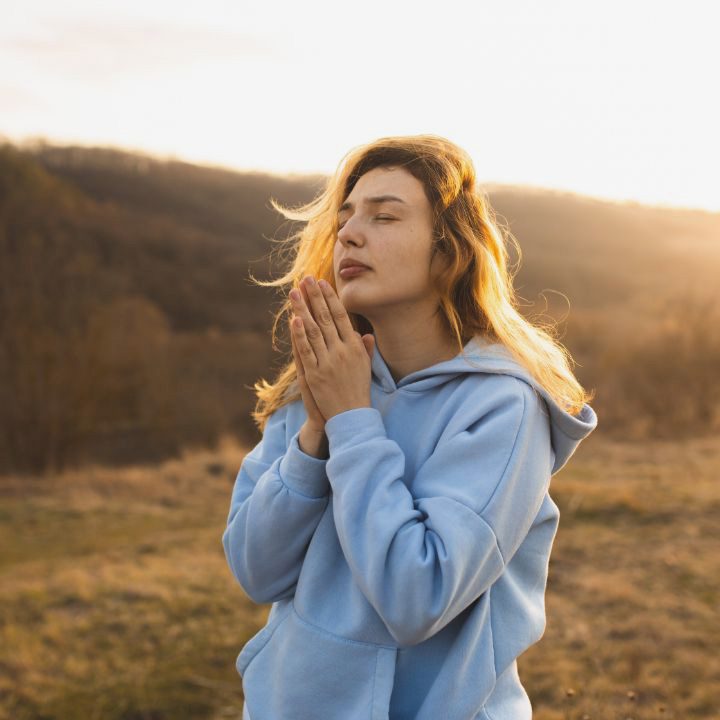 woman praying in a field